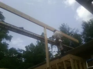 Carpenter setting a ridge beam over a new addition frame — Ice Dam Removal by Roofing Brothers in Wayne